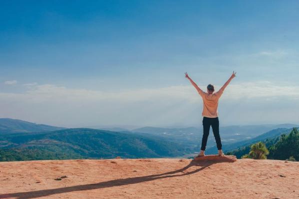 person standing on a beach with arms stretched out